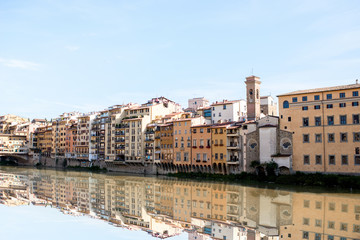 Cityscape view on the riverside with the old buildings and palaces near Holy Trinity bridge in Florence