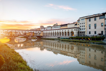 Fototapeta na wymiar Cityscape view on Arno riverside with Canottiery arch building and famous bridge on the sunset in Florence