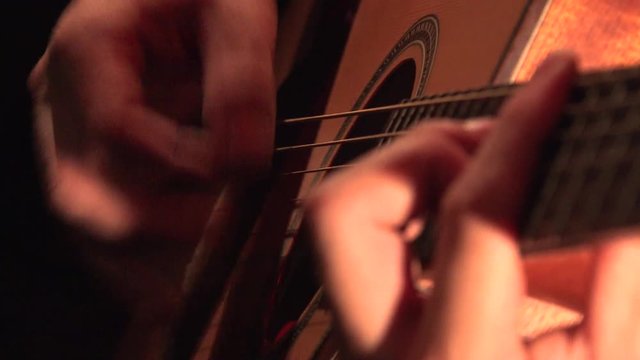 Hands of young man playing acoustic guitar