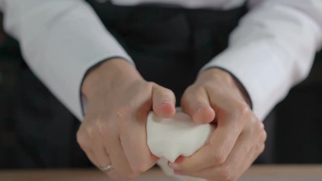 Woman's hands knead sugar mastic for making dessert