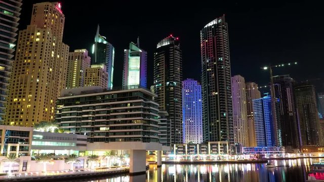 UHD 4K Dubai Marina night zoom out time lapse, United Arab Emirates. Dubai Marina - the largest man-made marina in the world, is a canal city, carved along a 3 km stretch of Persian Gulf shoreline