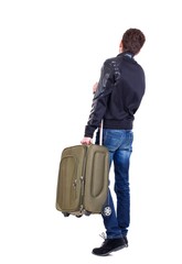 Back view of man with green suitcase looking up. traveler carries a suitcase.