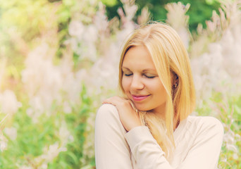 Fototapeta premium Young, charming, beautiful woman in gentle, warm atmosphere feels the touch of an angel on her shoulder. Outdoor portrait.