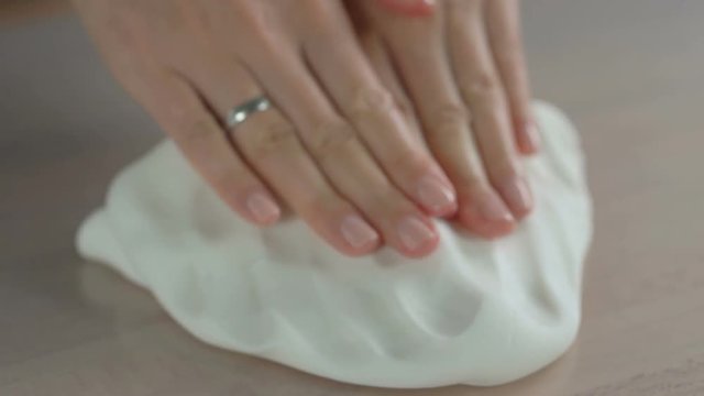 Woman's hands knead sugar mastic for making dessert