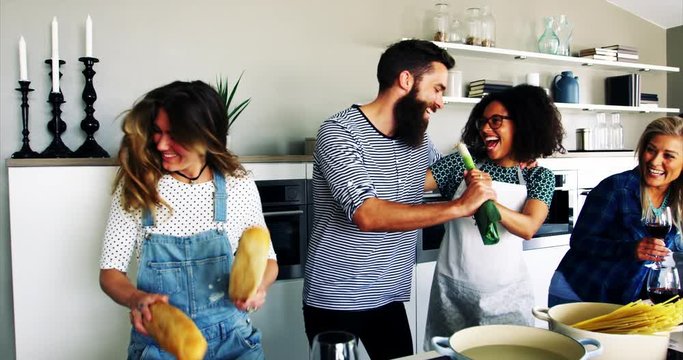 Friends having fun and singing in vegetables in kitchen