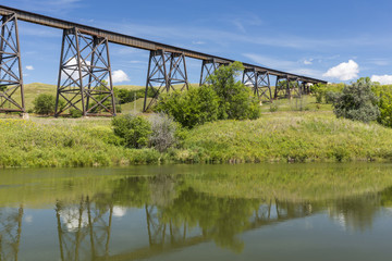 Fototapeta na wymiar Railroad High Bridge / A long and tall railroad bridge reflecting in a river.