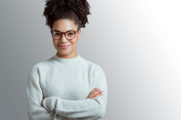Portrait of a young African American woman in glasses against gray background