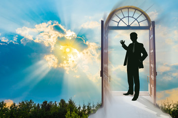Beautiful sky background at sunset, with a man in a doorway making the invitation gesture towards a brighter future
