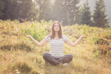 Beautiful girl meditating in the nature, at sunset