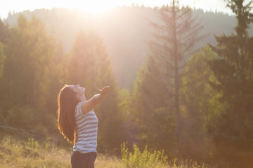 Beautiful girl meditating in the nature, at sunset