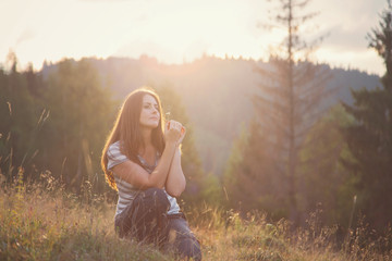 Young woman relaxing in the nature, at sunset