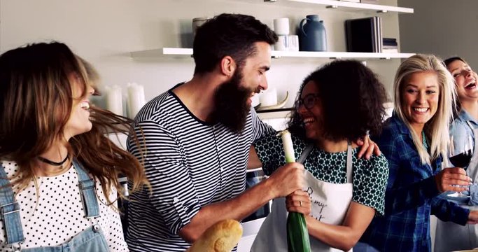 Friends having a good time laughing and fooling in kitchen