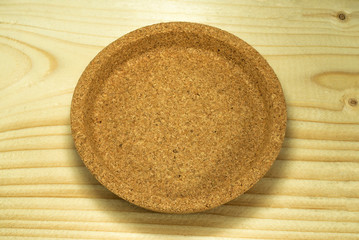 Round Cork drink coaster, on wooden background