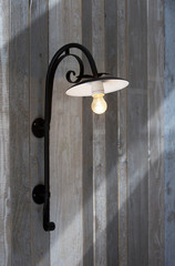 stylish rustic lamp on a wooden wall