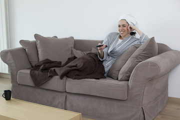 Obraz premium Young women in bathrobe in the living room watching TV