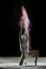 Sun Salutation - Young dancer traces patterns through a cloud of powder as she dances against a dark background