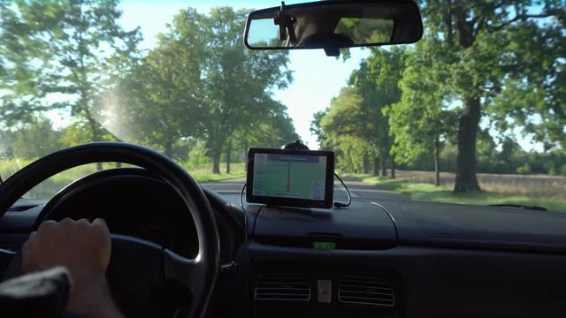 GPS navigation in car with man driving 4K. Close up on navigation screen showing road to follow. Smartphone navigation device.