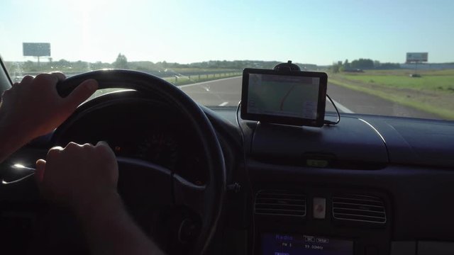 GPS navigation in car with man driving 4K. Close up on navigation screen showing road to follow. Smartphone navigation device.