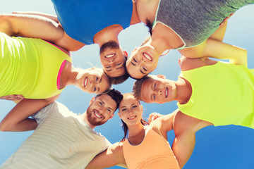 group of happy sporty friends in circle outdoors