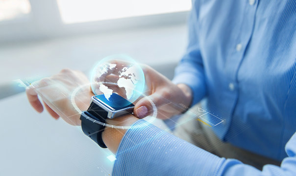 close up of hands and globe hologram on smartwatch