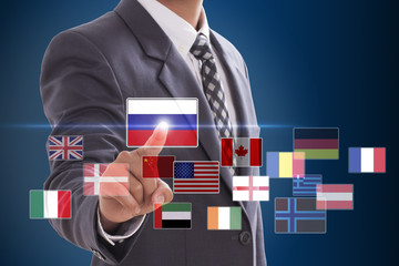 Businessman pushing on a touch screen interface, choosing Russia Flag 