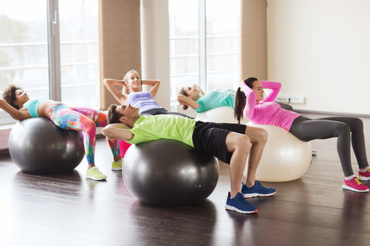 happy people flexing abdominal muscles on fitball