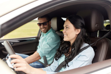 happy man and woman driving in car