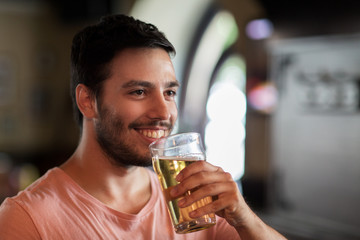 happy man drinking beer at bar or pub