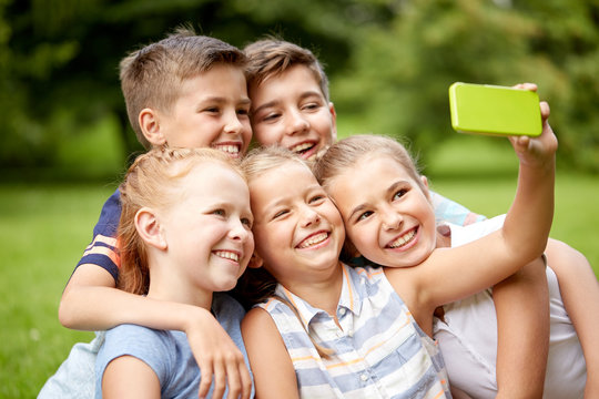 happy kids or friends taking selfie in summer park