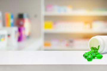 medicine pills on counter with blur shelves of drug in the pharm