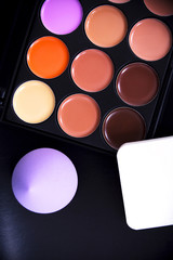 Palette concealer and correctors. Make-up base. Isolated on black background