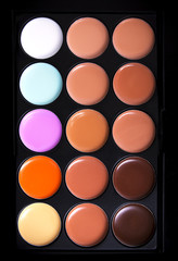 Palette concealer and correctors. Make-up base. Isolated on black background