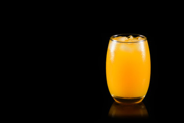 Orange juice glass on black background