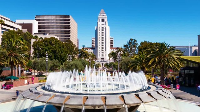 Time-lapse of Los Angeles City Hall with a fountain in Grand Park in the foreground