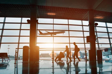Fotobehang Luchthaven mensen op de luchthaven, silhouet van jong gezin met baby die per vliegtuig reist