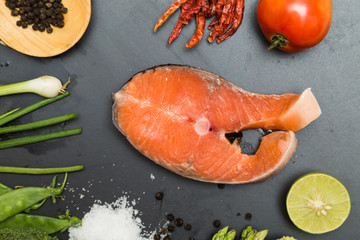 Salmon fillet on flat black rocks with lime chilli tomato salt a