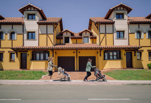 Side view of running women with prams