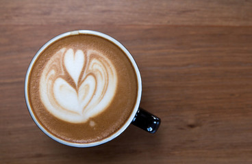 Latte art coffee with froth shape heart by close up top view