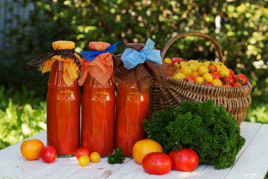 Tomato juice with parsley in a bottle on wooden table, horizontally, rustic. 