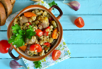 Vegetable stew with meat and barley on a blue background