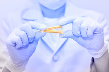 Yellow umbilical cord clamp used to clamp off the umbilical cord