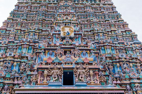 Madurai, India - October 19, 2013: Part of the East Gopuram of the Meenakshi Temple fills entire photo. Abundance of pastel colored statues of gods, goddesses and more.