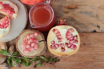 Ripe pomegranates with juice on wood background.