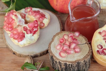 Ripe pomegranates with juice on wood background.