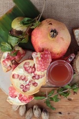 Ripe pomegranates with juice on wood background.