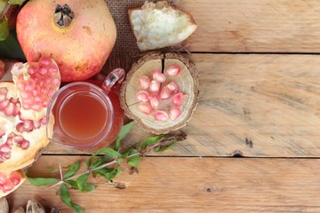 Ripe pomegranates with juice on wood background.
