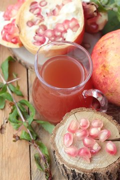 Ripe pomegranates with juice on wood background.