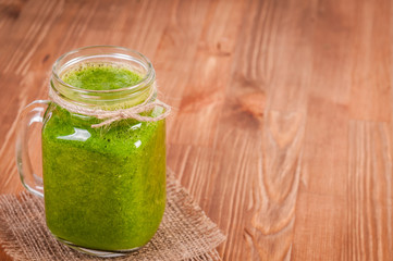 Jar mugs filled with green fresh organic spinach and lime lemon smoothie. Detox concept.