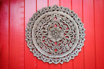 Asian decoration. Floral ornament on the red wooden wall.