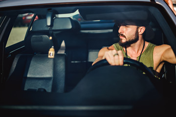 Naklejka premium Hipster man driving a car on a sunny day